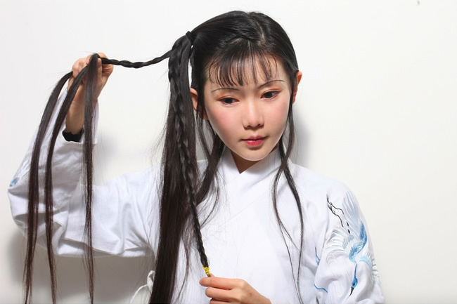 8.将之前后面没做发髻的剩余头发取一半，编成发髻，最后定型的时候会用。