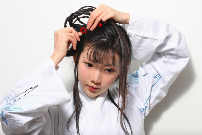 16.将最后一髻头发顺前两辫子固定处（以画红圈为准）固定，并向后绕将其余头发固定。