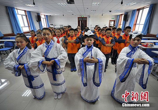 4名学生身穿汉服互相行汉礼，并为全班同学教授传统礼仪。