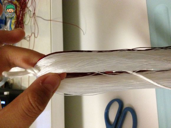 第六步：整理流苏线，现在流苏线应该包裹住中间的玉线b端。珠子和玉结也应该藏在线里面