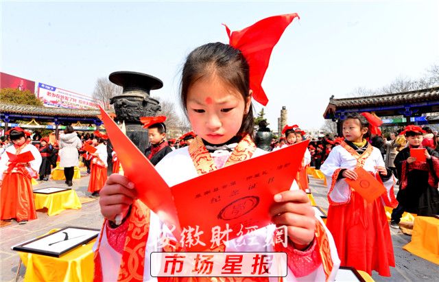 图为孩子们观看颁发的证书。