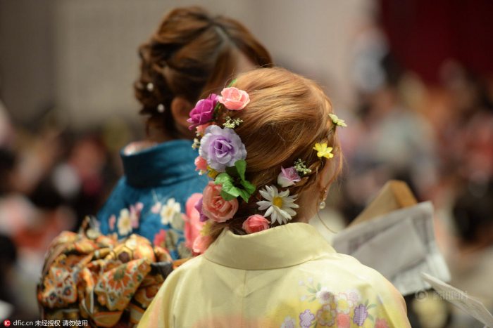 毕业式上，一名女生头戴多彩头饰，许多女生喜欢在毕业季上身穿绚丽多彩的服饰。