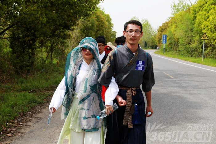 毅行者身穿汉服挽手踏步。