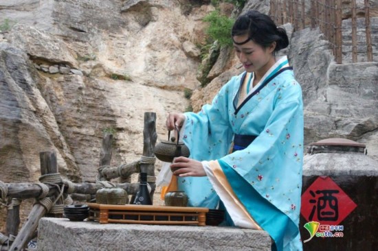在上九山景区一酒坊景点内，身着汉服的美女正在表演斟酒
