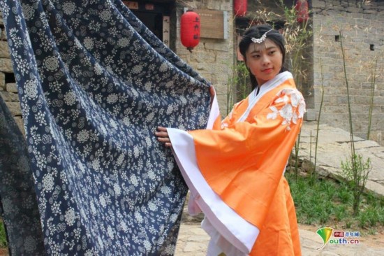 在上九山景区粗布坊景点身着汉服的美女正在展示印花粗布