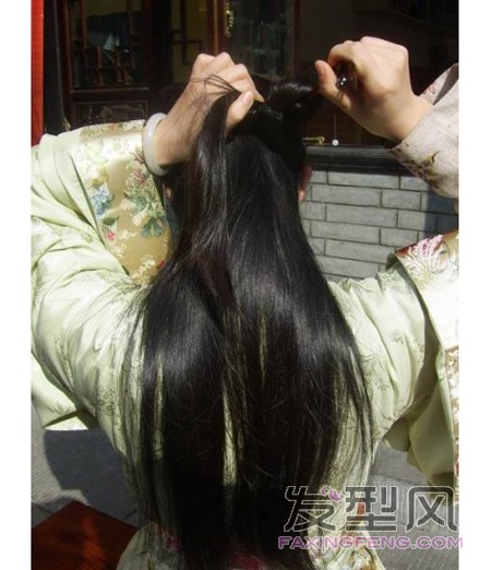 7、簪子的尖端尚未从头发中钻出来的时候，左手手指把先前绾的第一个圈拉到簪子下方，让簪子的尖从这个圈的上面出来