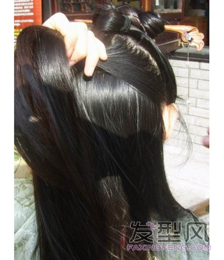 5、右手把这些新捞起的头发缠绕着绾成髻，紧挨着前面绾的髻放在其左边，用黑色钢夹固定住