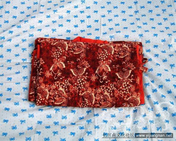 三、中衣上衣的折叠方法（上襦可对照）

一手持住两腋接缝底端，另一手持住两只袖口接缝处，齐整之后放平