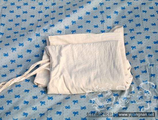 四、直身类的折叠

一手收住下摆开衩处四只角，另一手收住两只袖口接缝处，提起衣服放平