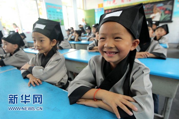 一名小学生身穿汉服在课堂上露出开心的笑容