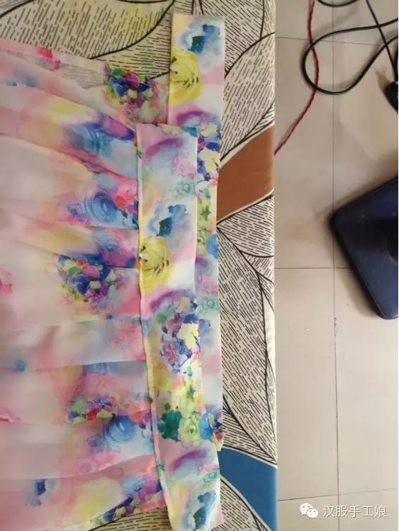 16、现在把裙头多出来的地方往里折熨平。把飘带的毛边塞进裙头，缝好。