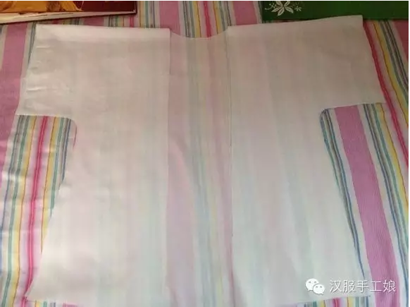 4、把后幅对折整平熨平车一条0.7cm的中线，汉服形制上的中线，代表中正。（注：原作者此处是为了形制而仿中线的做法，也可不选择这种剪裁方式，按照剪裁图进行剪裁，然后再缝合。因为这种剪裁方式最为简单，适合入门级。手工娘接下来会推送另一种剪裁图。）