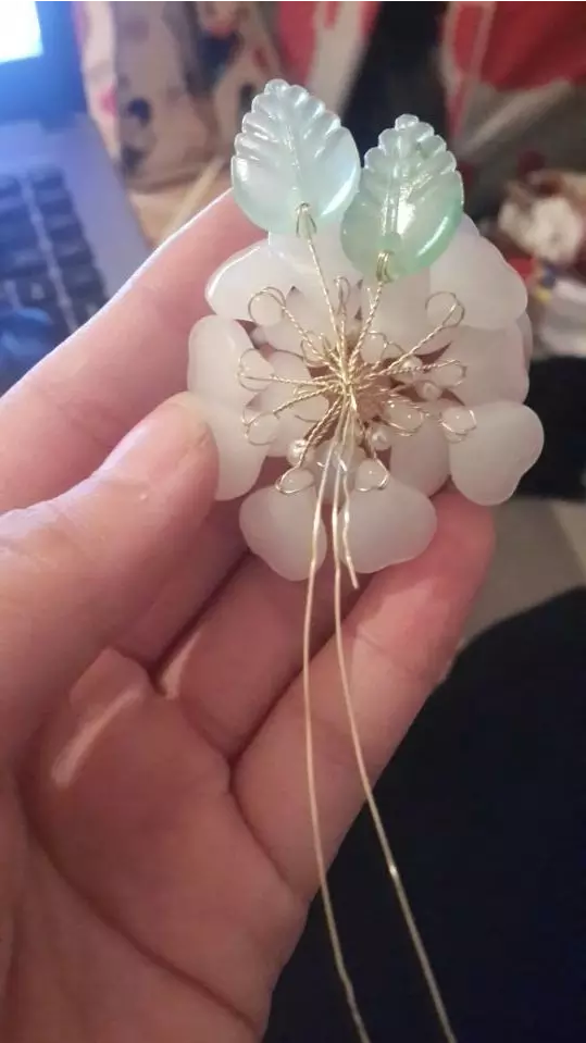 3、首先是材料。主材是花瓣和铜丝，辅材是8毫米玉石圆珠和4毫米ABS小珍珠树叶、花托、热熔胶、插梳【辅材是完成整个茶花插梳准备的啦】楼主准备做的是双层花，下面一层十片，上面五片的组合，总15片