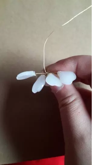 12、这里再来一个细节，是可以防止每个花瓣的脚跑偏的小窍门，那就是，绑好一个花瓣以后，让铜丝伸到对面的位置去，然后在把对面的花瓣绑好。不要拘泥于每次绑好一个花瓣就去绑相邻花瓣，那样最容易造成花瓣脚跑偏