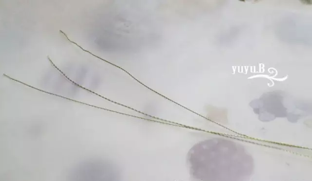 8.把拧好的铜线在设计稿上沿着边缘线用镊子制作图形。 