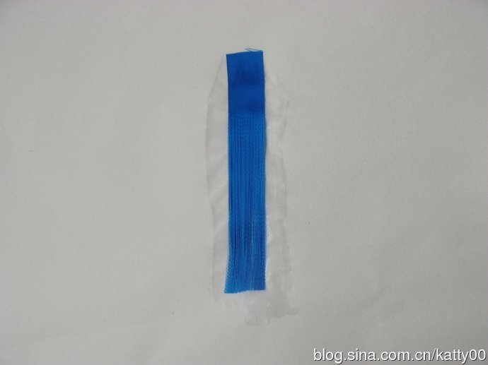 15.把丝排绷直，贴在已涂抹过浆料的宣纸上。注意做此道工序时，丝排一定要绷直，先贴好上端（未抽丝部分），再顺势将下端按压在宣纸上，这一步不需要整段丝排都贴牢在宣纸上，只是起个暂时固定的作用。
 
（一般这一步我的手势是这样的：右手拇指和食指捏牢上端，左手食指和中指作剪刀状夹在上端，顺丝排“捋”下，停在下端，然后两手一起拉紧绷直丝排，按贴在宣纸上。）