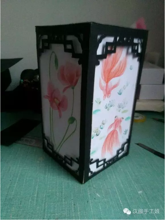 9、做铁丝提手，找一根铁丝拧成如图的样子，然后把铁丝拧的提手卡在开口的地方。如没有铁丝可自己在灯笼顶端挖个洞用绳子穿过。