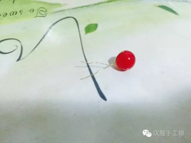 小花片和中花片之间滴上热熔胶，将珠子穿过他们，珠子和小花片之间也滴点胶，更牢固
