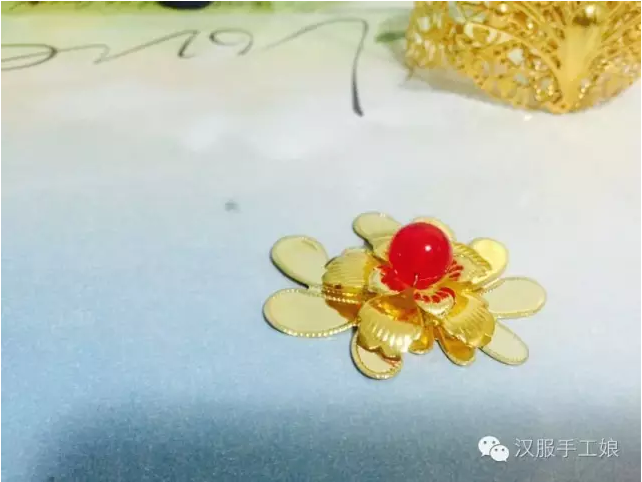 9、将树叶用铜丝绑在发圈上（这里不要偷懒用胶水直接粘上，树叶要是不牢固会直接导致整个发冠前面的装饰掉落），然后将刚刚做好的装饰用热熔胶贴在树叶上面。