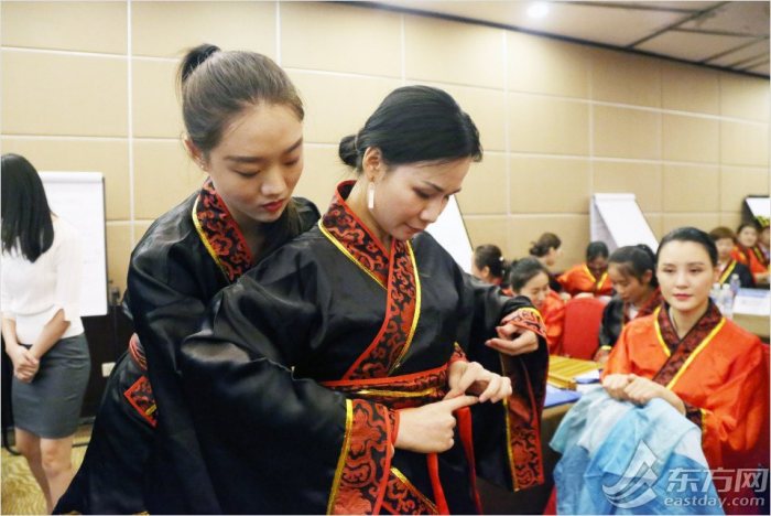 学员们身着汉服,互相帮助整理汉服的领和衽。