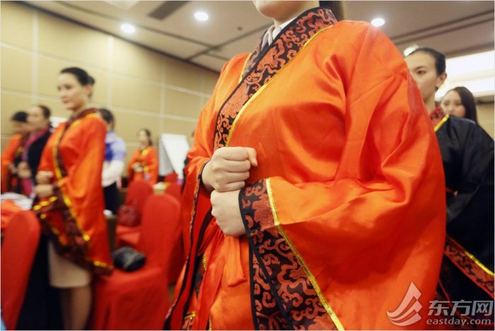 图为学员们模仿礼仪培训师的手部礼仪动作。