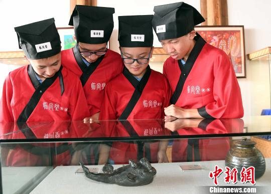 身着汉服的福州中学生参观福州福建省海峡民间艺术馆展品。